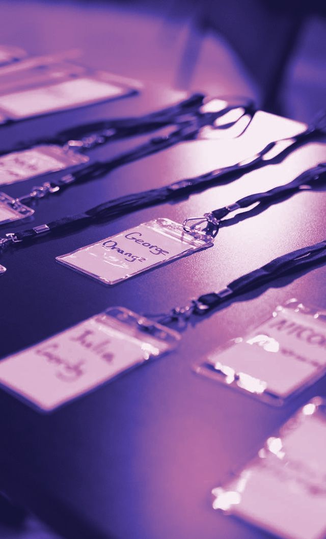 Credenciais com cordão organizadas na mesa de recepção de um evento